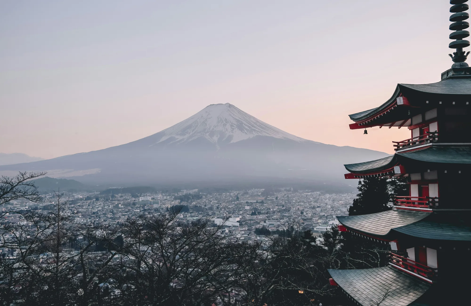 Monte Fuji innevato visto da una pagoda giapponese al tramonto