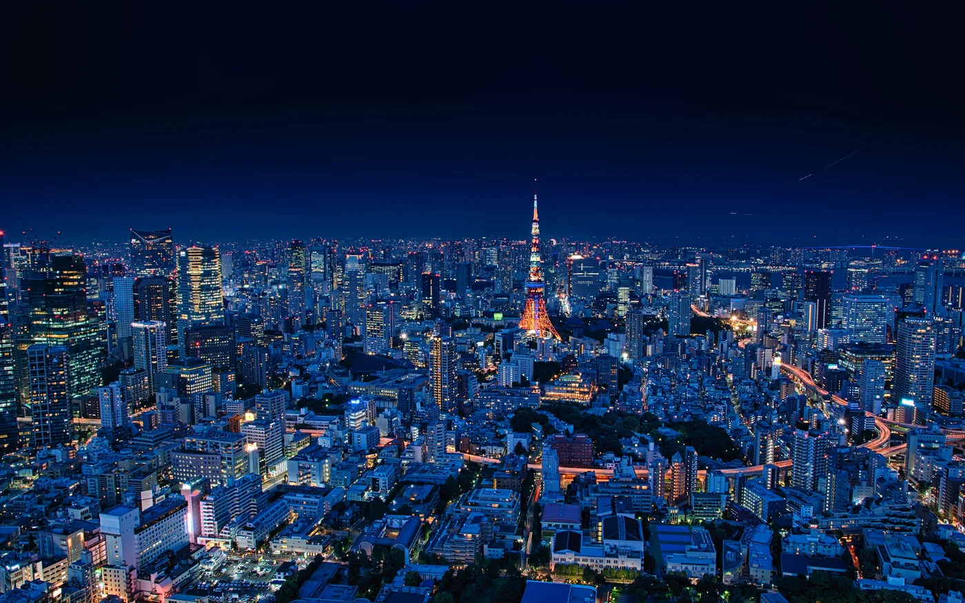 Tokyo di notte vista dall'alto, con la Tokyo Tower illuminata in mezzo ai grattacieli